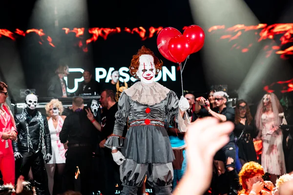 Host v kostýmu klauna před dalšími soutěžícími na pódiu