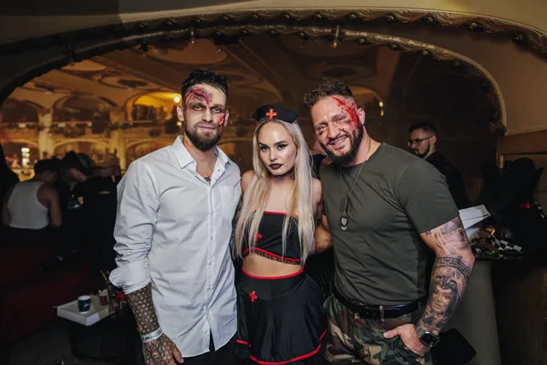 Trojice hostů s halloweenským líčením pod historickým stropem Lucerny
