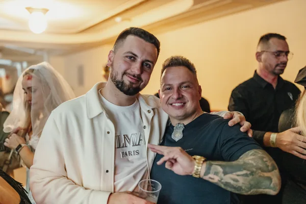 Dvojice usměvavých hostů pózuje v předsálí Lucerny